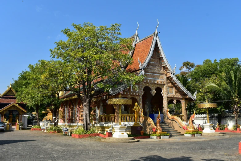 a thai temple sits on the corner of a paved parking lot