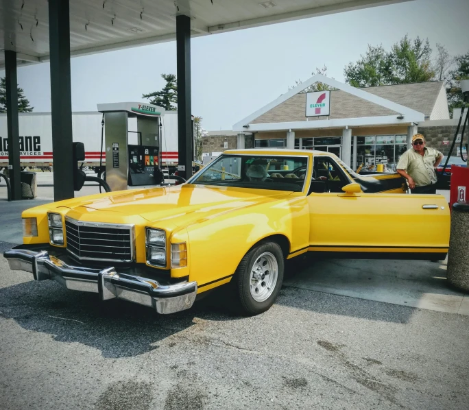 an old yellow chevy truck in a parking lot