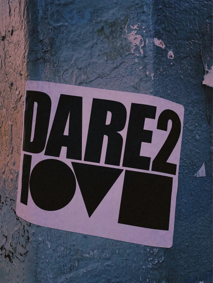 sticker on the side of a building that says dare 2