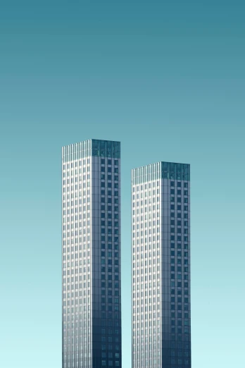 two tall buildings are shown against the blue sky
