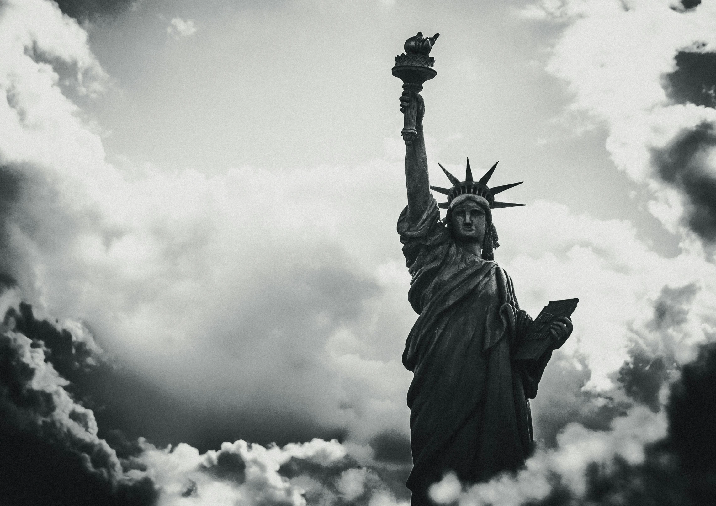 the statue of liberty stands out among the clouds