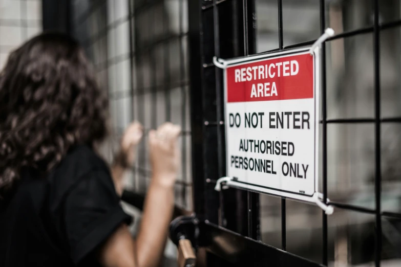 a red and white sign is attached to the side of a fence