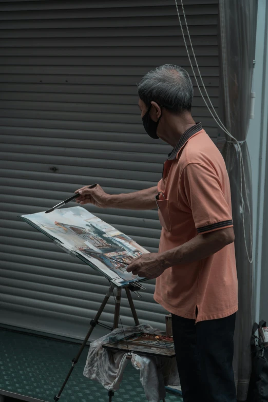 an older man is painting with his hands