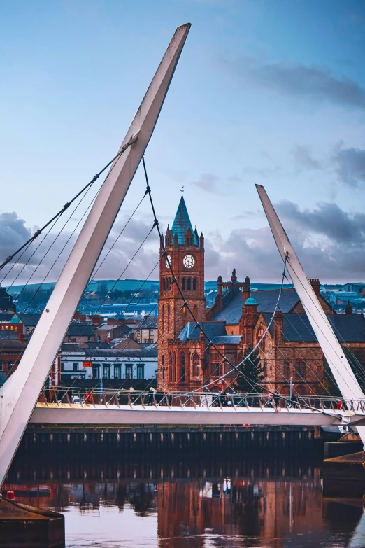 a cathedral sitting behind a tall bridge that spans over a river