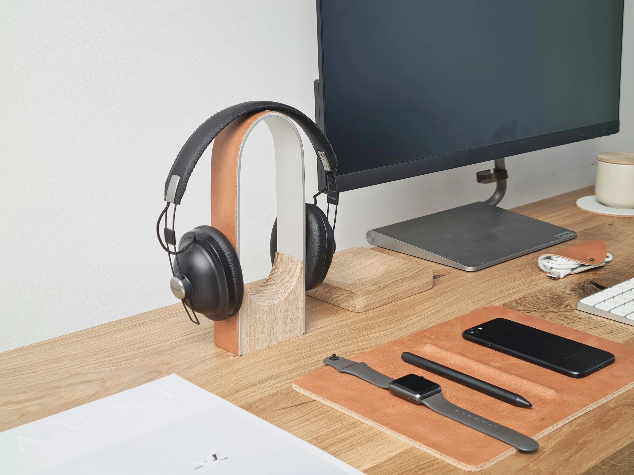 a computer, ear phones and keyboard on a table