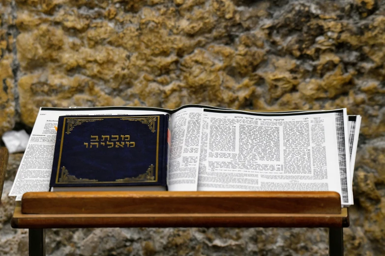 an open bible sits atop a table with two pieces of paper