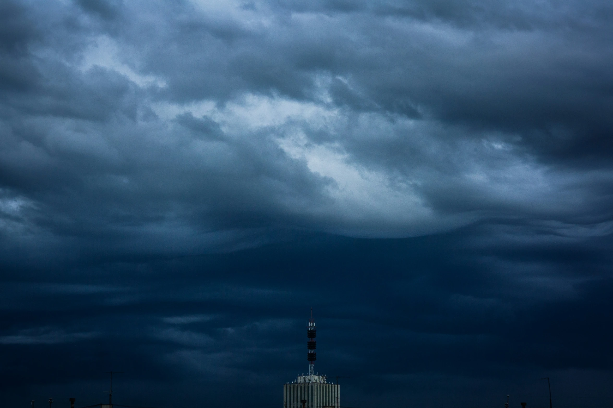 a sky filled with dark clouds and a building