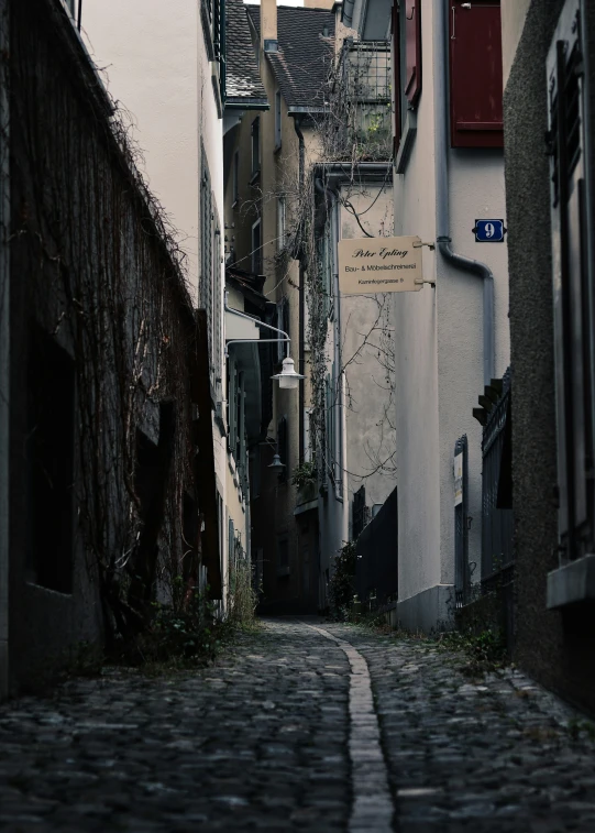 a narrow road between two buildings with a street sign