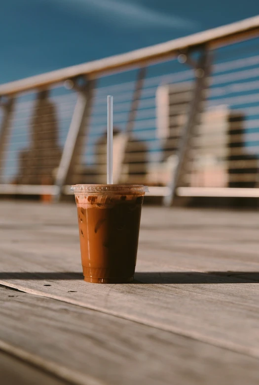 the top half of a drink cup with straw sitting on the ground