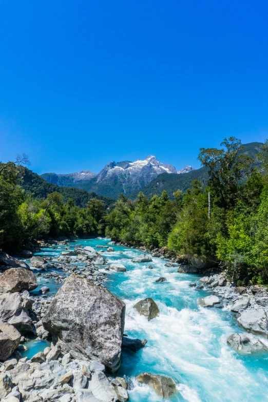 a mountain river flowing between some rocks in the middle of a forest