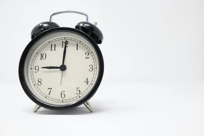 a small black alarm clock sits on top of a table