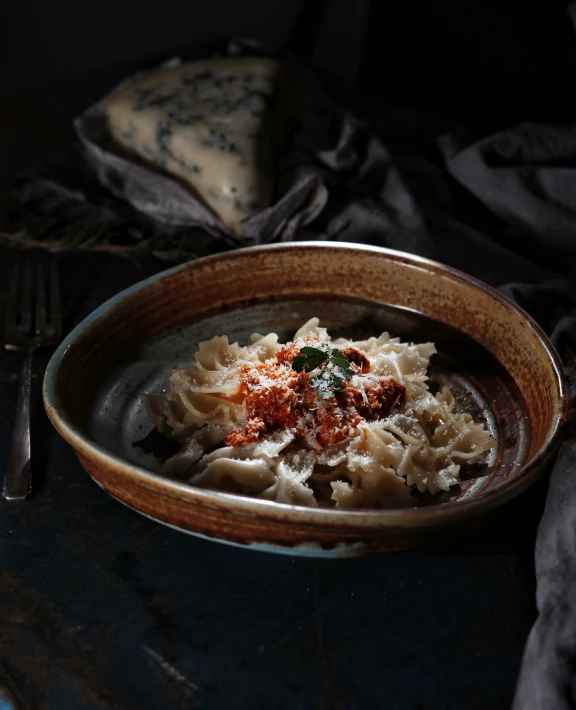 a bowl filled with pasta and sauce sitting on a table