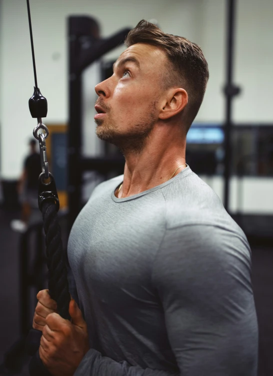 a man hanging on the ropes while holding onto a rope