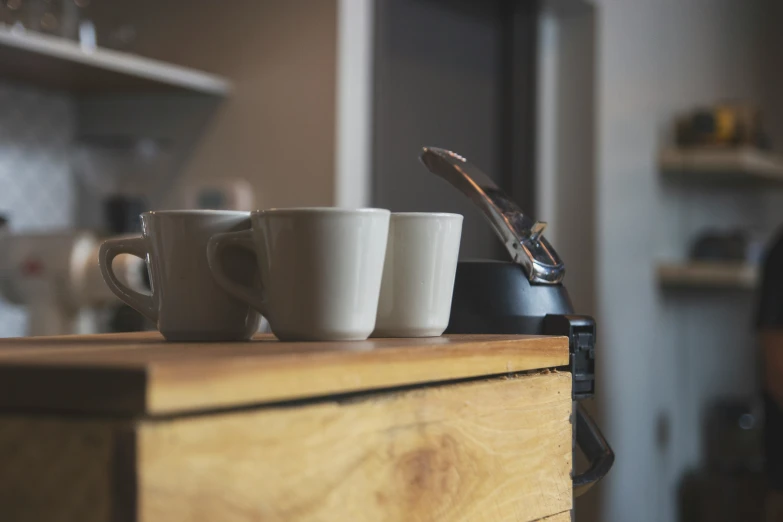 a man standing next to two mugs on a dresser