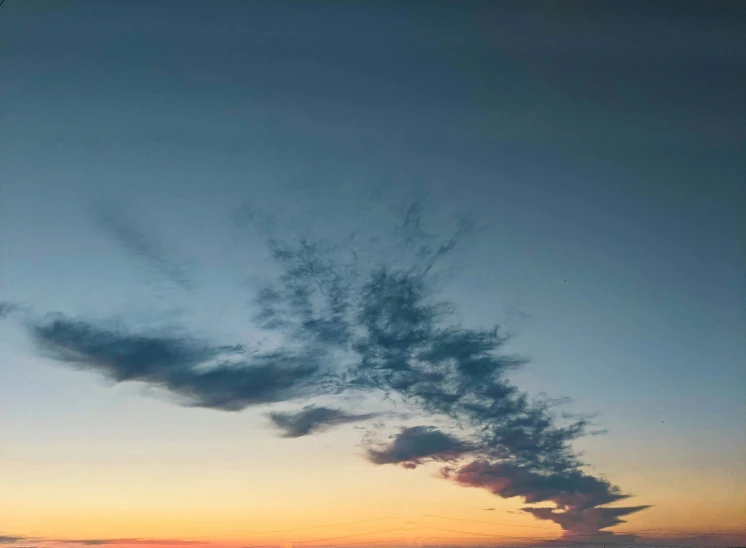 a very large cloud in the sky over the water