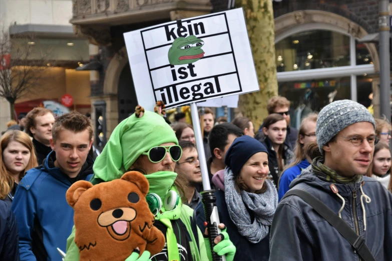people walking in a crowd holding signs with characters on them