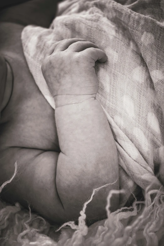 a newborn baby is sleeping on a bed with a fluffy blanket