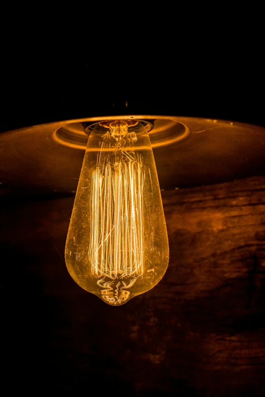 an old style light bulb hanging on a wall