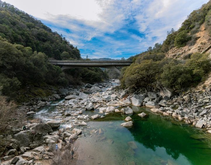 a river surrounded by rocks and rocks with a bridge over it