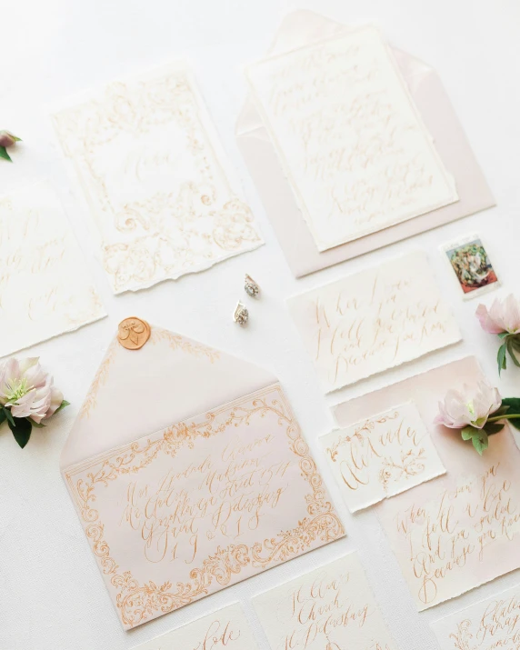 a pile of different colored cards with some pink flowers on them