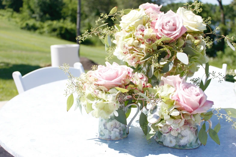 two vases full of flowers are sitting on the table