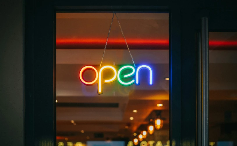 a restaurant window with neon open sign displayed at night