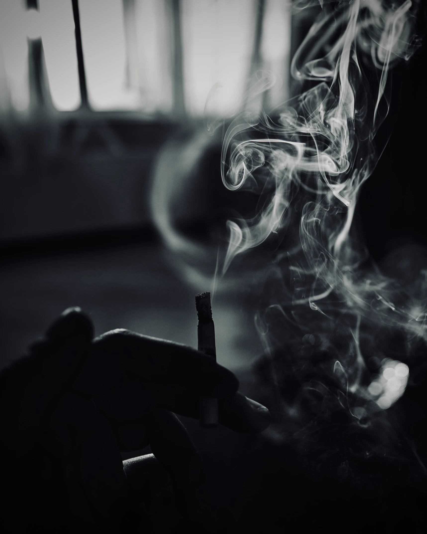 a hand holding a smoking stick full of smoke