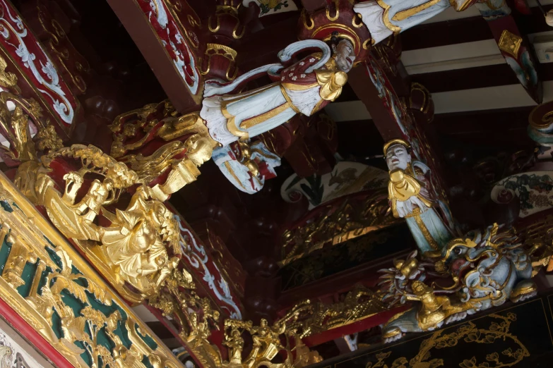 many golden and red statues on a wall