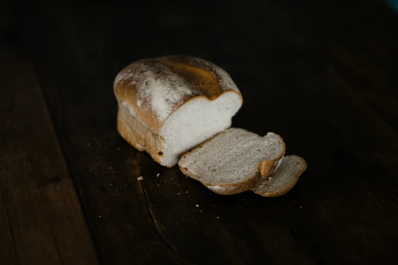 a slice of white bread that has been broken off on a table