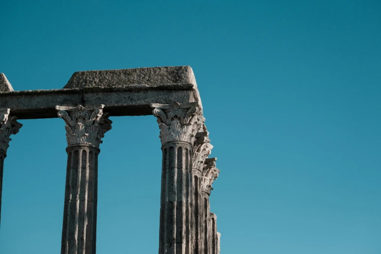 a bird is sitting on the pillars of a building