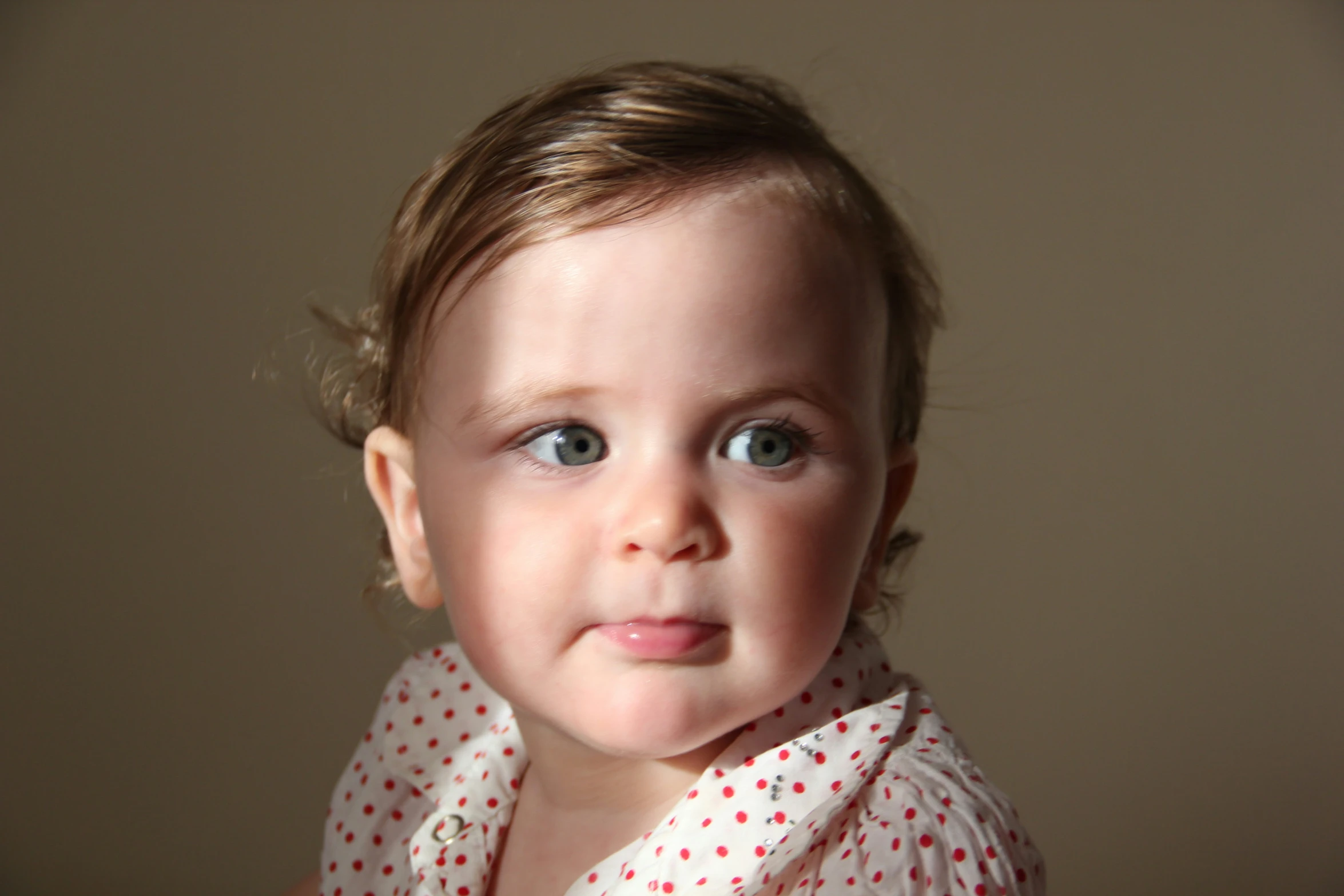 a little girl with blue eyes has a surprised look on her face