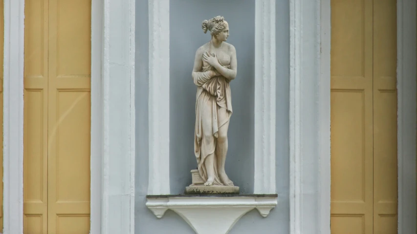 a statue is sitting in the center of an outside wall
