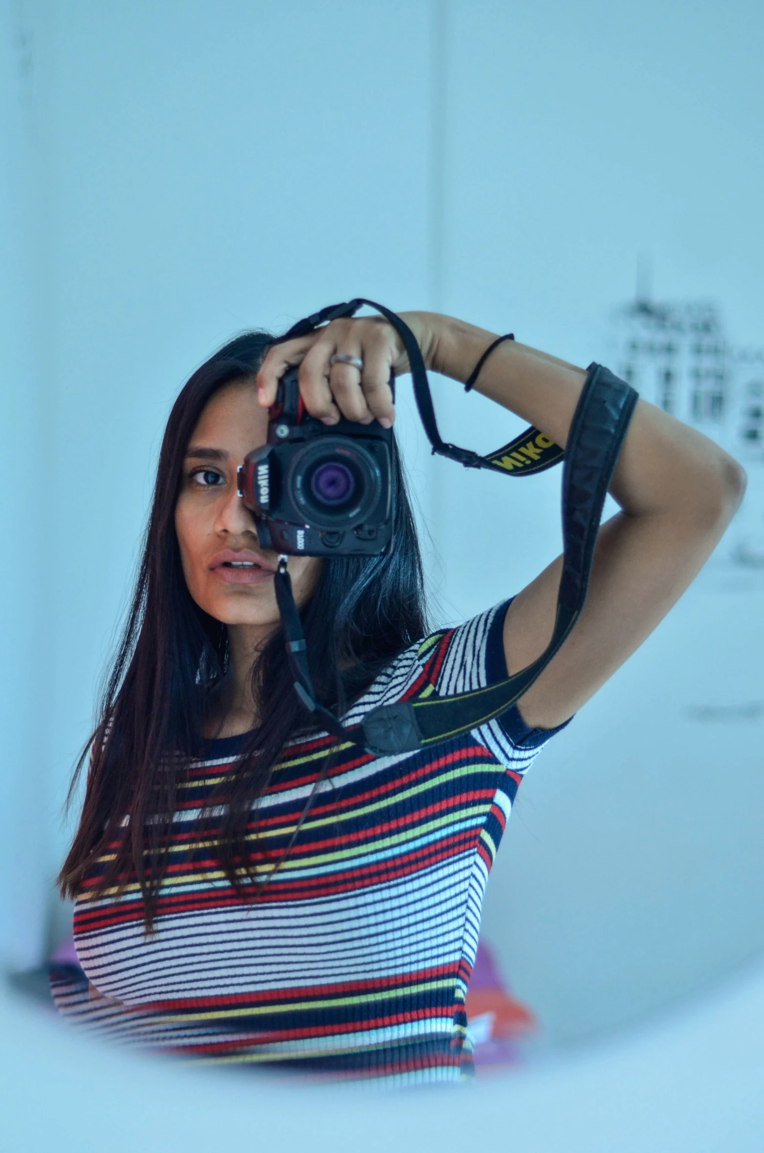 a young woman taking a selfie in the mirror with a camera