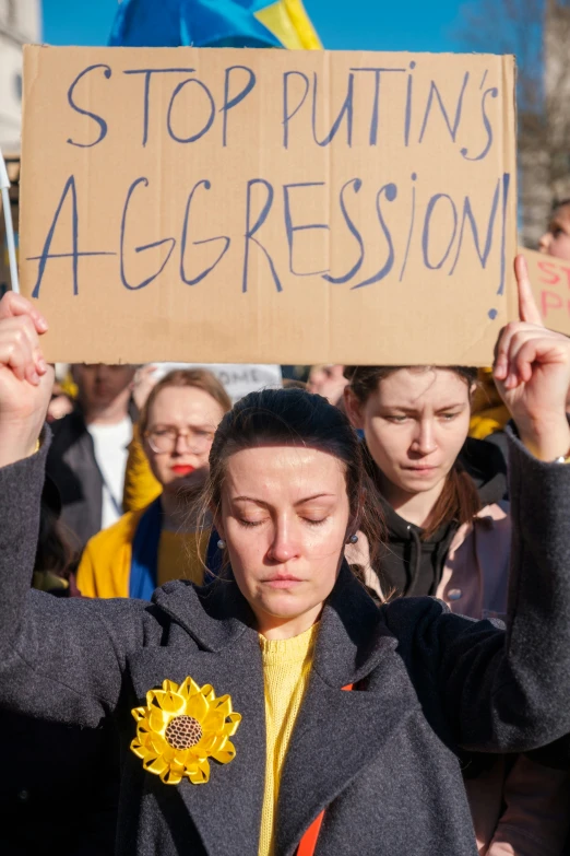 protestors at a demonstration, one holding a sign