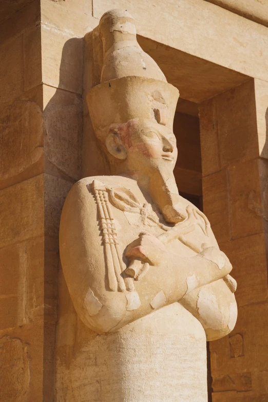 a sculpture of a statue sitting next to a large building