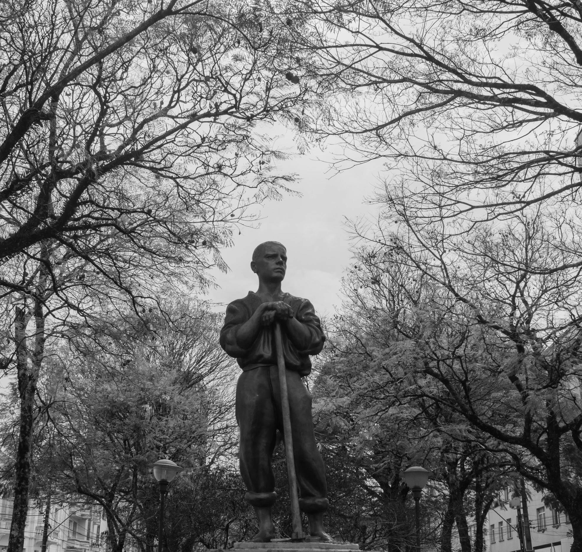 a statue of a man with a baseball bat in a park