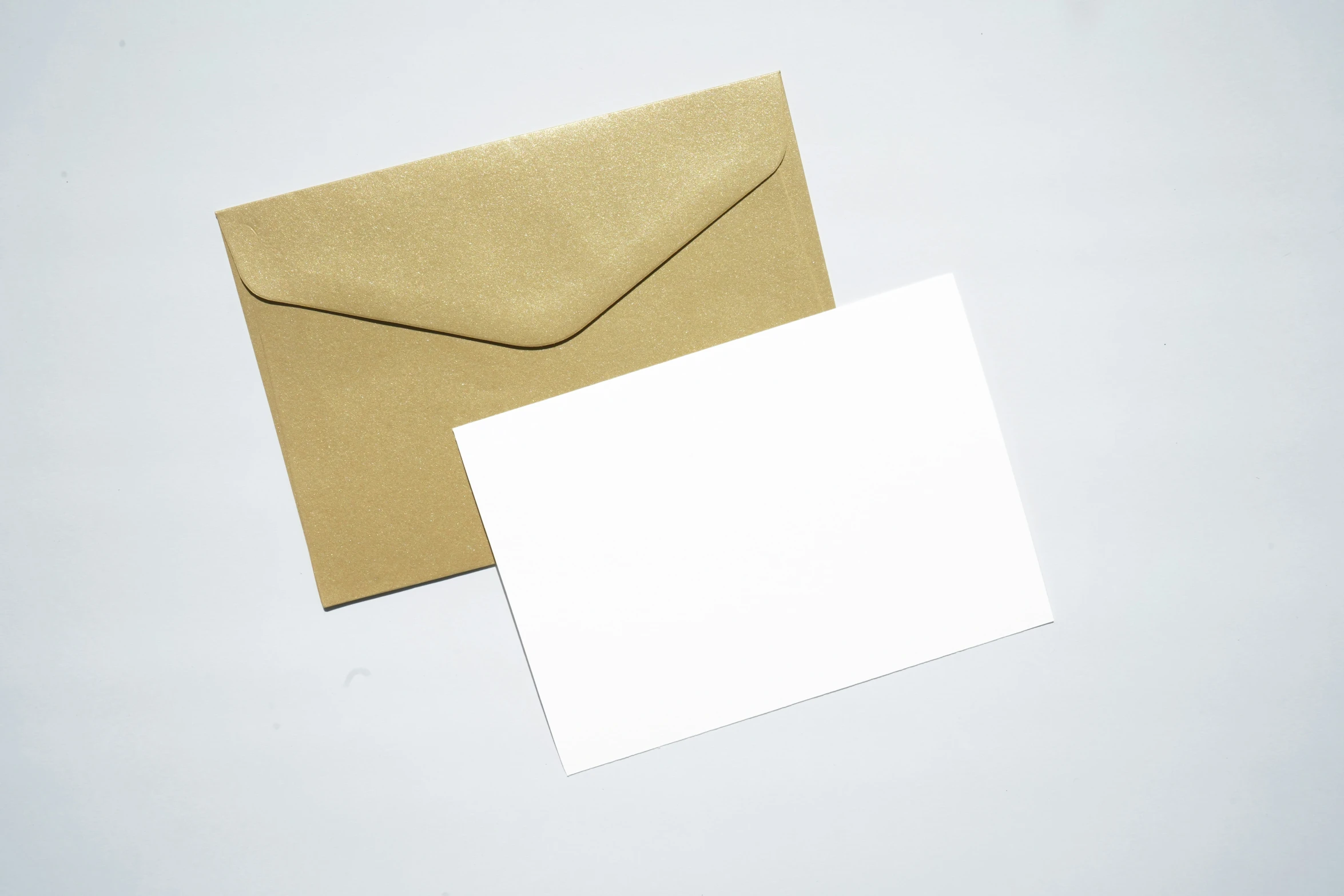a white envelope and gold foil card