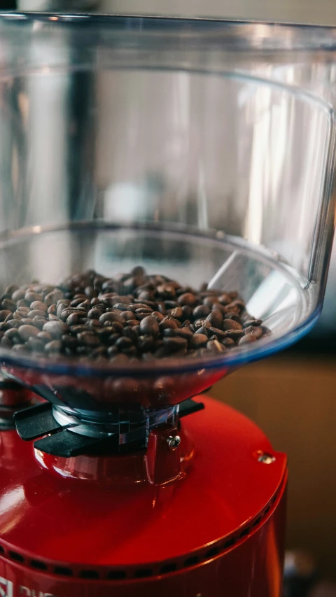 coffee beans are falling out of a red machine