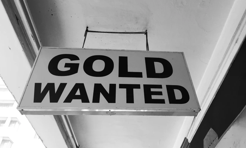 a black and white sign that reads gold wanted