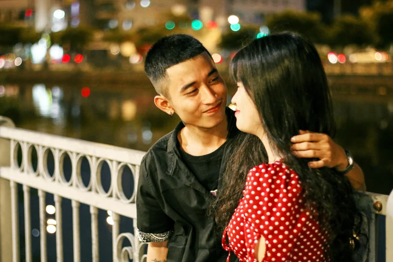 a couple posing for a picture while leaning against a railing