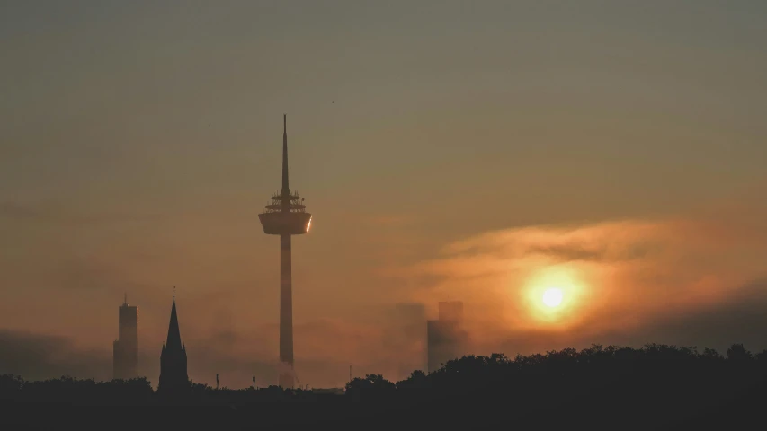 the tower stands above the trees at sunset