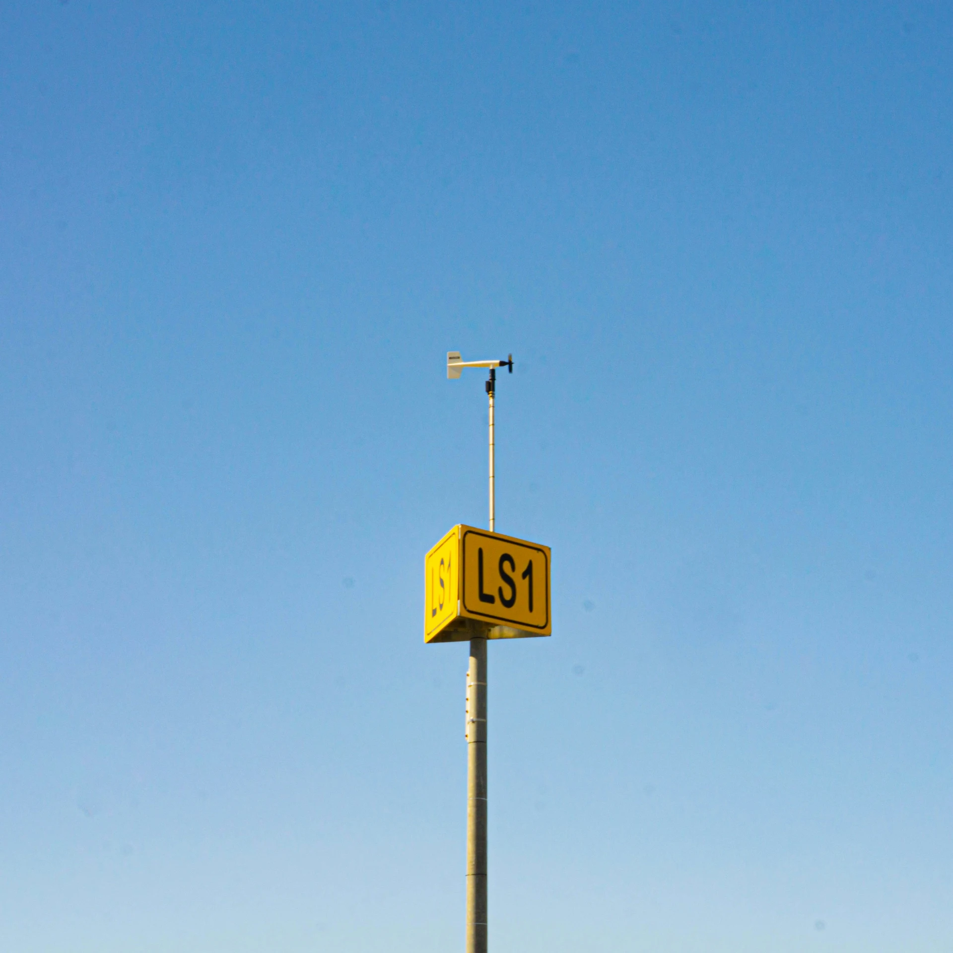 a tall sign sits above a building with an antenna on top