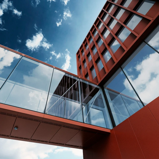 a high - rise building is against a partly cloudy blue sky