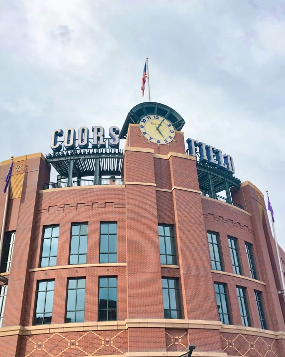 the front of a brick building with a clock on top of it