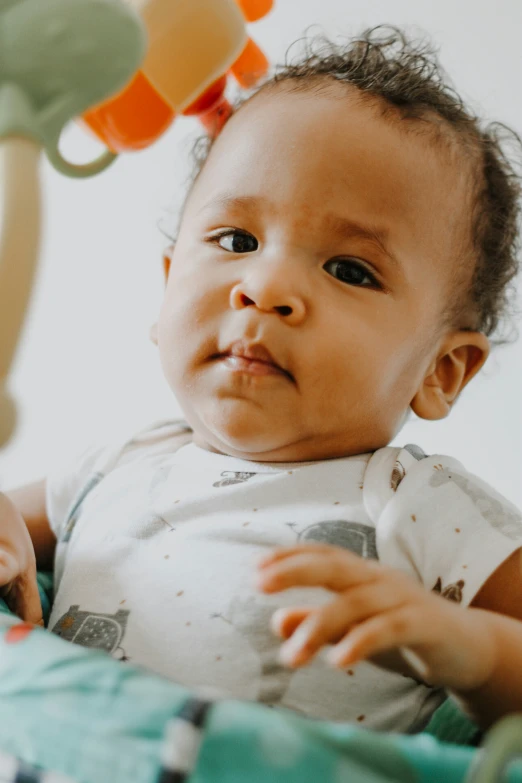 the infant is looking at soing on the head