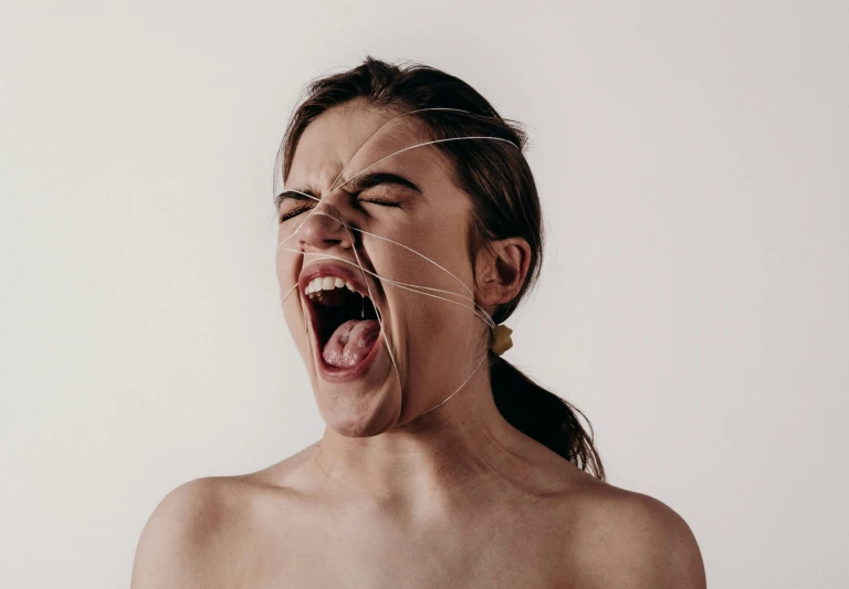 a woman with her mouth open and a string over her tongue