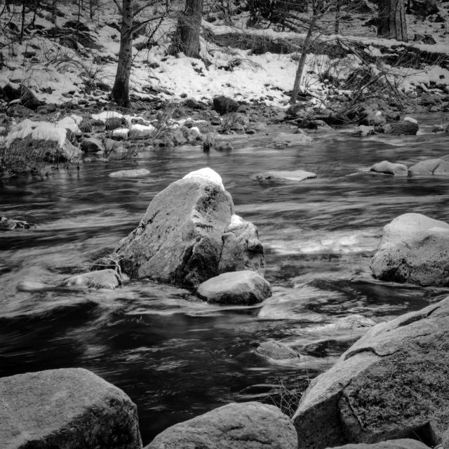 a river flows between some rocks in the woods