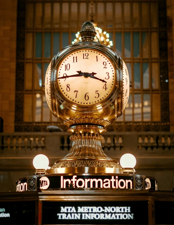 a clock with a gold statue next to it's logo