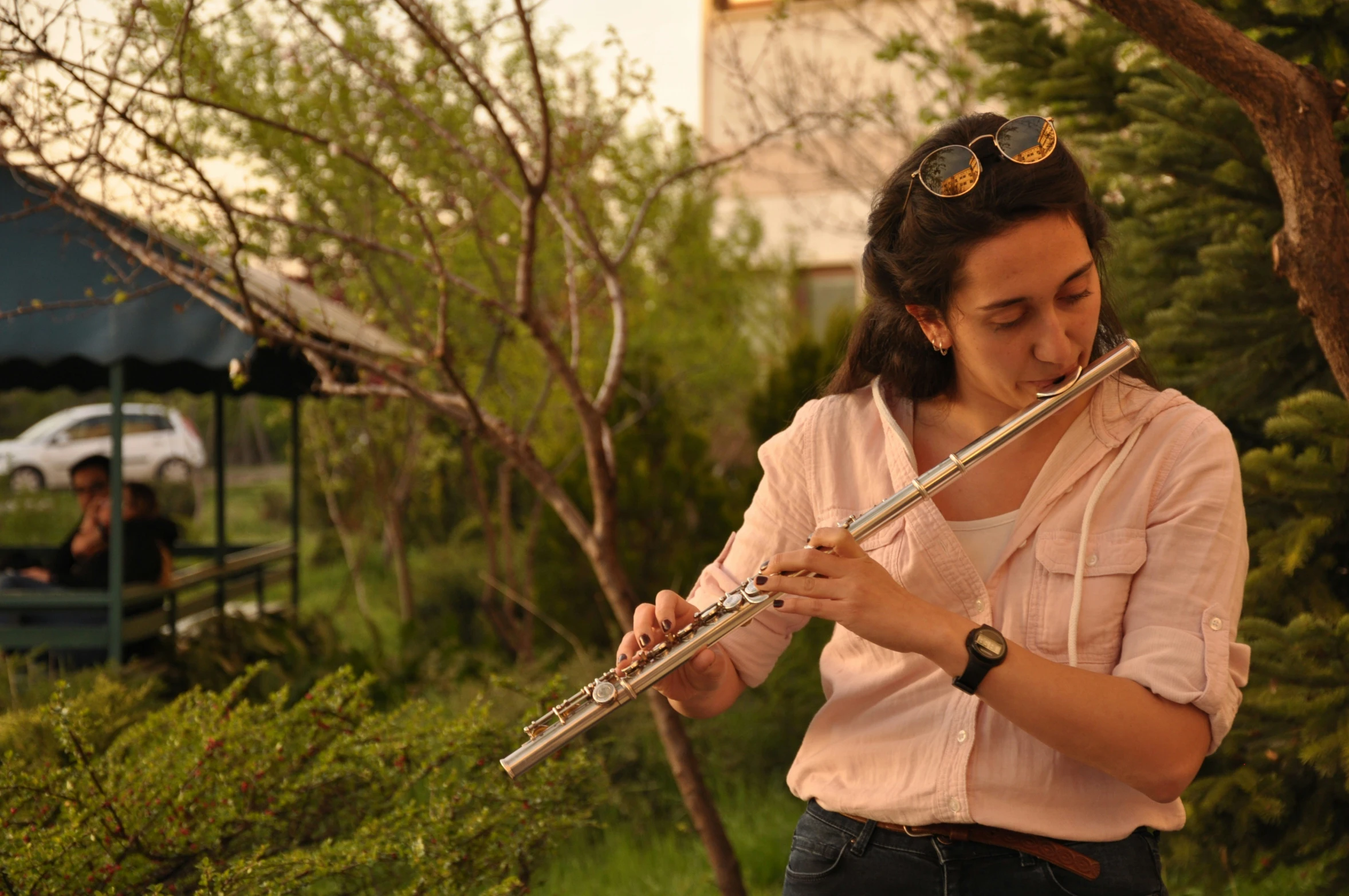 a woman in pink shirt playing a flute