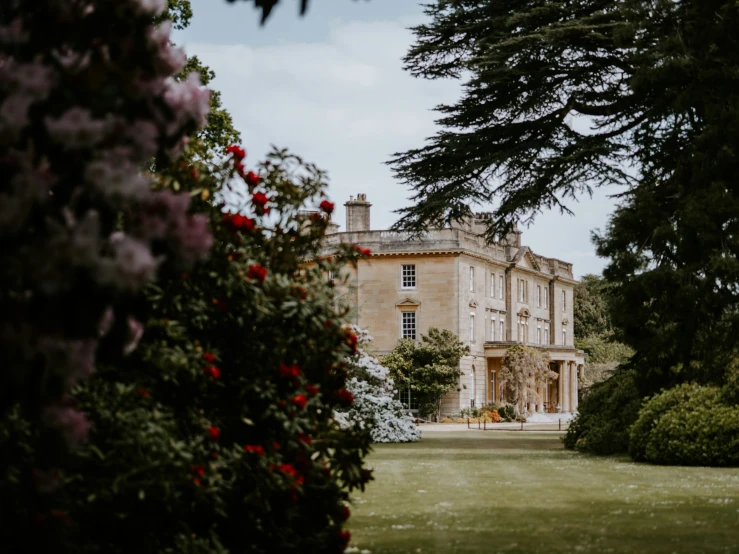 a very big nice looking house surrounded by pretty flowers